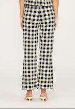 Load image into Gallery viewer, Woman wearing a Navy and white checkered jumpsuit on a plain background
