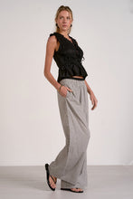 Load image into Gallery viewer, Woman wearing a black sleeveless top and checkered pants on a white background
