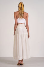 Load image into Gallery viewer, Woman wearing a white top and long cream skirt with a yellow headscarf on a plain background

