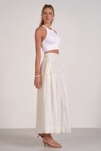 Load image into Gallery viewer, Woman wearing a white top and cream-colored skirt against a plain background
