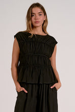 Load image into Gallery viewer, Woman wearing a black tiered top against a plain background
