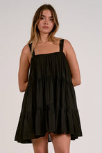 Load image into Gallery viewer, Woman wearing a black tiered dress against a plain background
