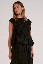 Load image into Gallery viewer, Woman wearing a black tier top with ruffled layers on a plain background
