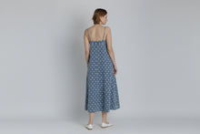 Load image into Gallery viewer, Woman wearing a blue polka dot dress on a plain background
