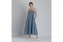 Load image into Gallery viewer, Woman wearing a blue polka dot dress with white shoes on a plain background
