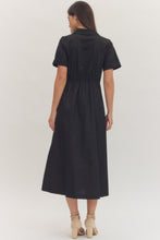 Load image into Gallery viewer, Woman wearing a midi length black dress with a bow at waistband on a white background.
