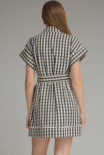 Load image into Gallery viewer, Woman wearing a black and white checkered dress against a gray background
