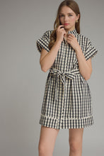 Load image into Gallery viewer, Woman wearing a black and white checkered dress against a gray background
