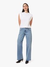 Load image into Gallery viewer, Model wearing a white sleeveless stop on a white background with straight legged blue jeans on.
