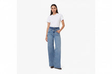 Load image into Gallery viewer, A model wearing wide-leg jeans over a white t-shirt, standing against a plain white studio background.

